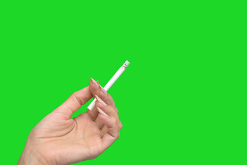 Female hand holding a smoking cigarette isolated on green screen