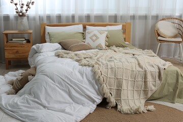 Fototapeta na wymiar Large comfortable bed with soft pillows, duvet and blanket in room. Home textile