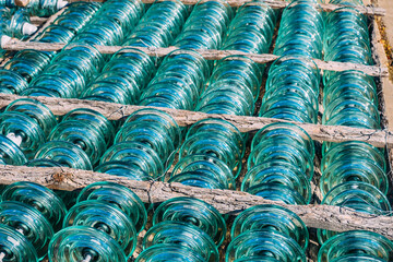 Glass transparent high-voltage insulator is in storage. Industrial background.