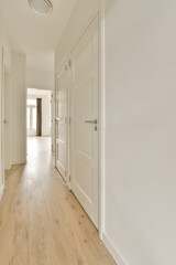 an empty room with white walls and wood flooring on the right side of the room, there is a door...