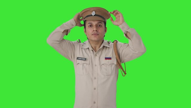 Happy Indian police officer wearing hat Green screen