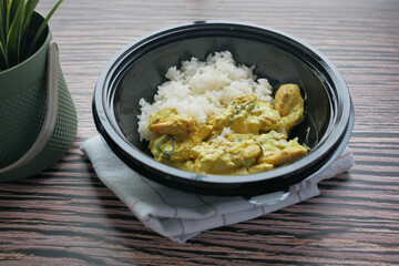 curry chicken and rice in a take away plastic packet on table 