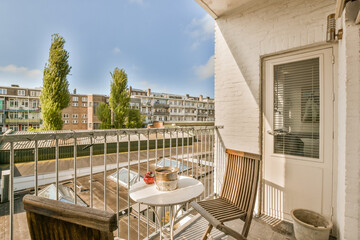 a balcony with an outside table and chairs on the left side, there is a blue sky in the background