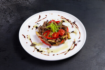 Salad with meat and tomato in a plate.