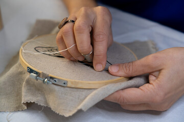 Hands of women embroidering by hand - obrazy, fototapety, plakaty