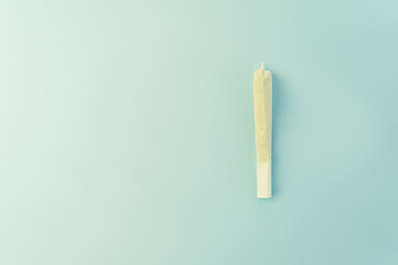Preparing a cannabis joint with tobacco and rolling paper with marijuana bud on blue background. The insinuation of marijuana abuse. cannabis legalization concept. copy space