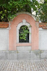 Mauer mit Fenster und Blättern