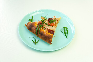 Homemade pizza with marijuana or cannabis leaves on white background. Fresh medical marijuana, cannabis decorate on pizza.