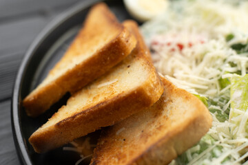 Delicious caesar salad with parmesan cheese and toast croutons, close-up