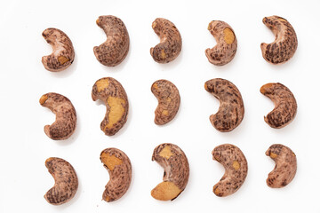 Burned cashews nut with peel on white background.