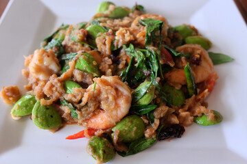 Delicious spicy Stir Fried bitter beans with Shrimp on white plate