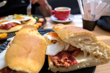 View of a egg and bacon sandwich and an omelet in the background in Ios Greece