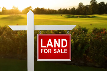 LAND FOR SALE SIGN on empty meadow - Real estate conceptual image. - obrazy, fototapety, plakaty