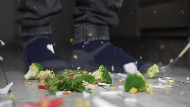 A plate of vegetables and fruits broke into pieces on the kitchen floor