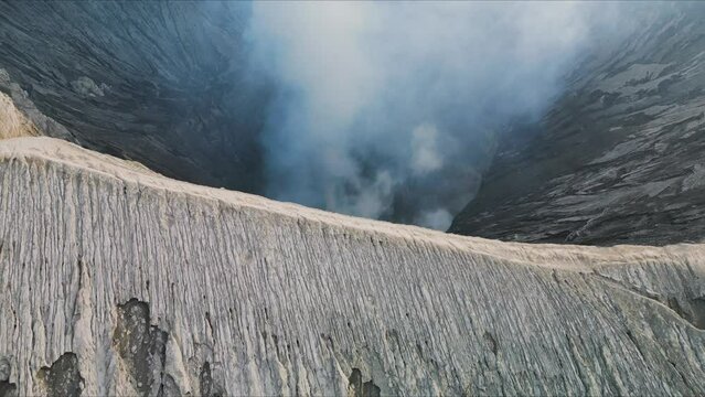 Bromo volcano caldera in Bromo-Tenger-Semeru National Park. Drone flying over a smoking crater