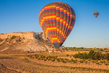 Hot air balloons flying over bizarre rock landscape in Cappadocia. Balloons fly early in the morning. Beautiful hot air balloons in the morning sky. Goreme. Turkey