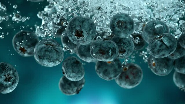 Super slow motion of falling fresh blueberries into water on blue gradient background. Filmed on high speed cinema camera, 1000 fps.