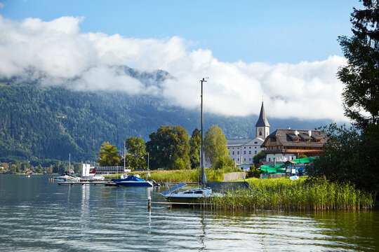 Ossiach Abbey, Lake Ossiacher See in Ossiach, Carinthia, Austria. Beautiful summer mountain landscape with church. A former Benedictine monastery and Alpine lake in mountains with white clouds