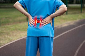 Lumbar intervertebral spine hernia, man with back pain on a running track after workout, spinal...