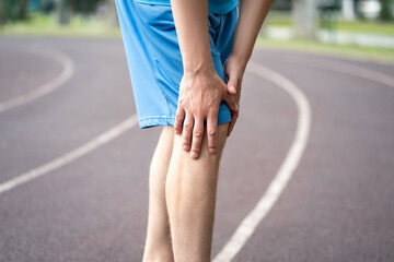 Diseases of the knee joint, bone fracture and inflammation, athletic man on a running track after...