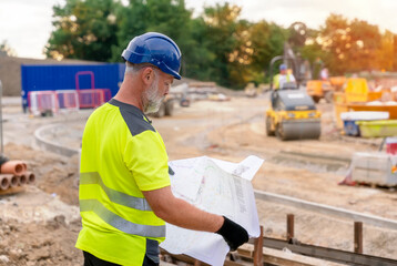 A builder site engineer surveyor working with theodolite total station EDM equipment on a building...
