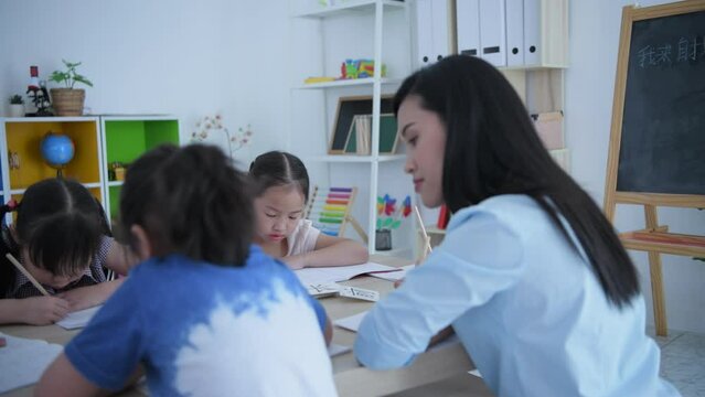 (Chinese wording translation:insect, introduction) Educational concept of 4k Resolution. The teacher is teaching children to learn Chinese in the classroom.