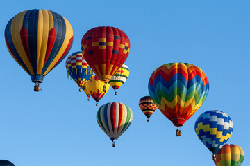 Multiple  hot air balloons in flight during a balloon festival © Denise