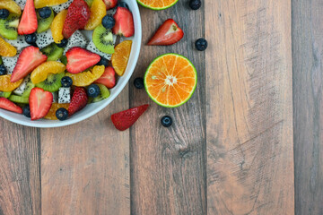 Fresh fruit salad bowl on wood grain table concept healthy food, to control weight, to lose weight