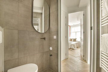 a bathroom with a toilet, mirror and towel rack on the wall next to the bathtub in the room