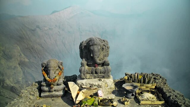 Ancient stone statue of Ganesha stands on a top of volcano Bromo