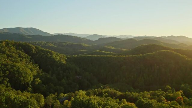 Vast forest hill panorama, Smoky mountains in Tennessee, aerial forward sunrise