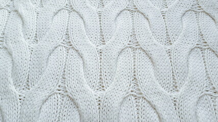 Cotton knitted decorative white fabric. Texture of knitwear. Cotton. Knitting with braids.