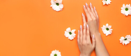 Female hands with beautiful manicure and flowers on orange background with space for text - obrazy, fototapety, plakaty