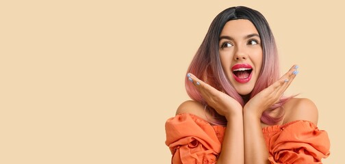 Portrait of beautiful excited young woman in wig on beige background with space for text