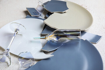 Broken plates and glasses on grunge table, closeup