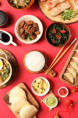 Composition with delicious Chinese dishes on red background