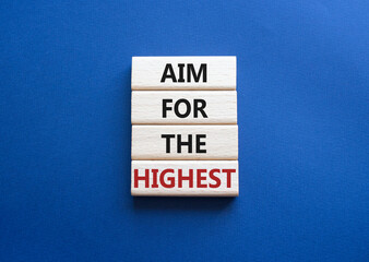 Aim for the Highest symbol. Concept words Aim for the Highest on wooden blocks. Beautiful deep blue background. Business and Aim for the Highest concept. Copy space.