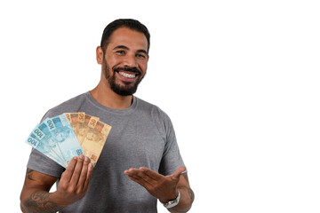 Man points to the Brazilian money in his hand, smiling, positive emotion