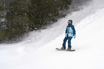 A lone snowboarder on a snowy slope. Copy space.
