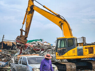 Excavator and Worker at Work in a Scrapyard