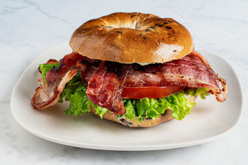 bacon lettuce and tomato on a blue berry bagel,