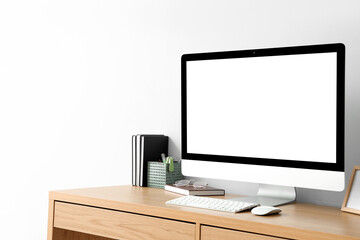 Modern workplace with blank computer monitor in light office - obrazy, fototapety, plakaty