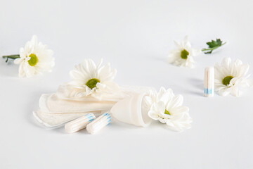 Fototapeta na wymiar Female hygiene items and chamomile flowers on light background