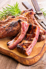 Barbecue veal spare ribs sliced with hot honey chili marinade served as close-up on a rustic design cutting board