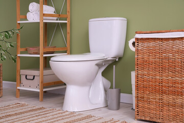 Interior of restroom with toilet bowl and shelf unit