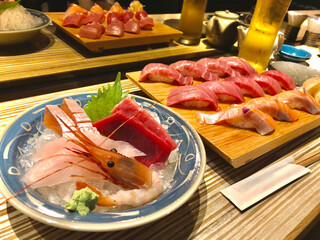 assorted sashimi bowl set and a wooden serving board of salmon and tuna nigiri