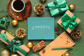 Beautiful Christmas composition with greeting card, gift boxes and cup of coffee on green wooden background