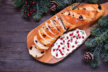 Cranberry baguette with pomegranate cream cheese spread. Above view table scene against a dark wood...