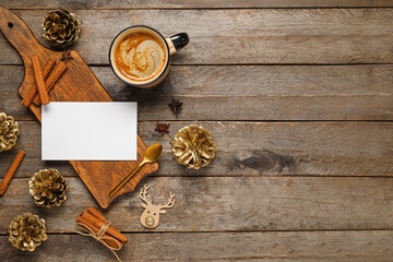 Beautiful Christmas composition with blank card, mug of coffee and decor on wooden background