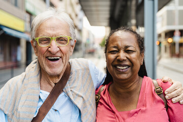 Happy multiracial senior friends having fun while waiting at the bus station